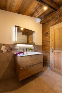 Badezimmer mit Waschbecken und beleuchtetem Spiegel